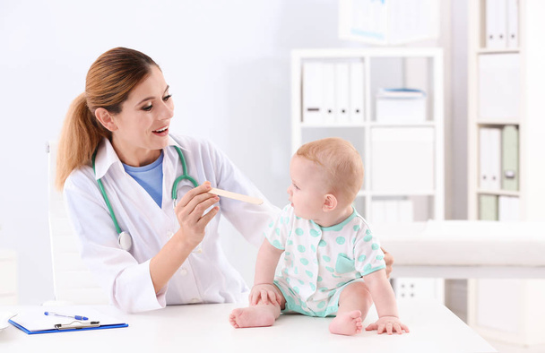 Детский врач осматривает горло ребенка в больнице
 - Фото, изображение