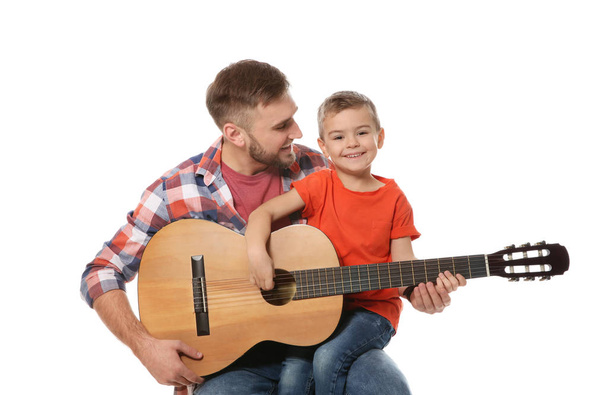 Vader onderwijs zijn zoontje om gitaar te spelen op witte achtergrond - Foto, afbeelding