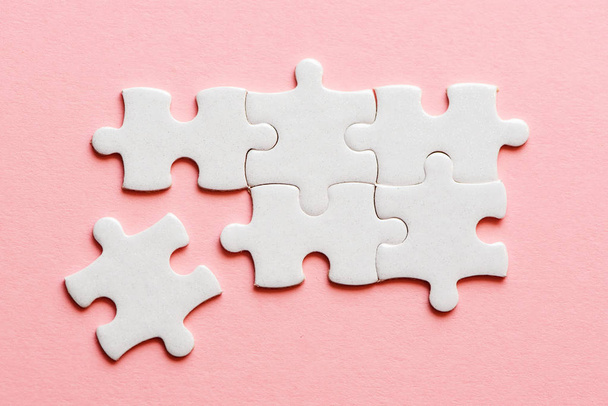White details of puzzle on a pink background. - 写真・画像