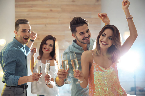 Friends clinking glasses with champagne at party indoors - 写真・画像
