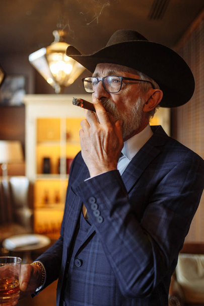 Concept of old age wisdom and experience. Old man with cigar and whiskey. - Foto, immagini