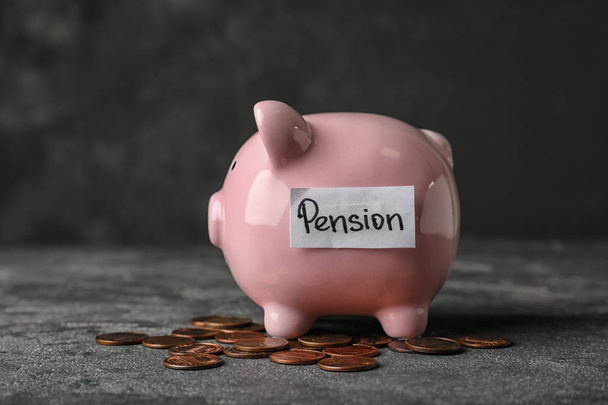 Skarbonka z word Pension i monety na stole - Zdjęcie, obraz