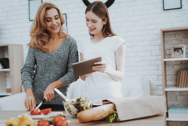 Smiling Mother and Daughter Cooking Together in Kitchen. Relationship in Family. Holiday at Home. Healthy Food and Lifestyle Concept. Cooking Together. Happiness in Family Concept. - Foto, Imagen