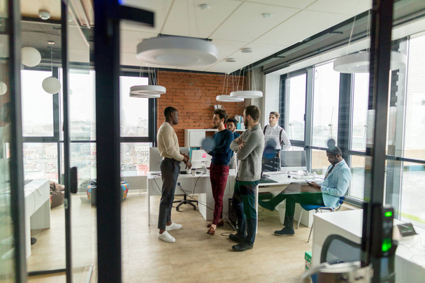 Les gens d'affaires dans un bureau à aire ouverte avec une fenêtre panoramique, long shot
 - Photo, image