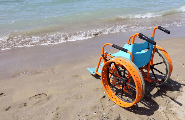 Spezielle Rollstühle auf dem Sand des Strandes mit großen Rädern auf dem Wasser des Meeres zu gehen - Foto, Bild