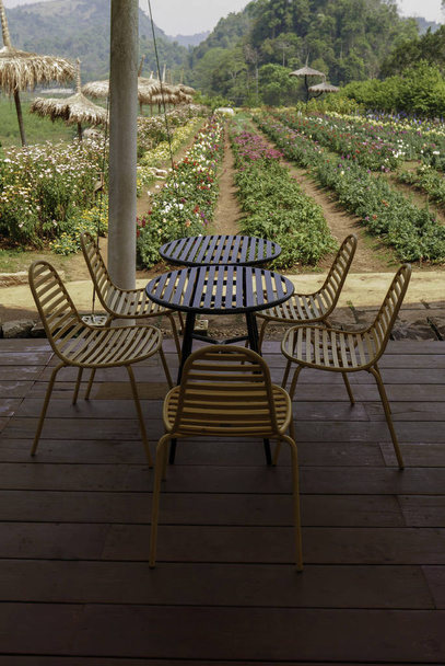Mesa al aire libre y sillas en bistro caf en el día cerca del jardín para la relajación, viajes, temporada, tiempo, vacaciones, agroturismo, concepto de agroturismo
 - Foto, Imagen