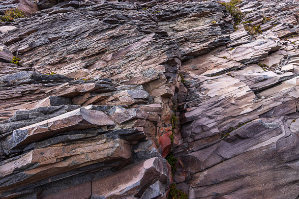 textuur van bruine en grijze gekartelde rotswand - Foto, afbeelding
