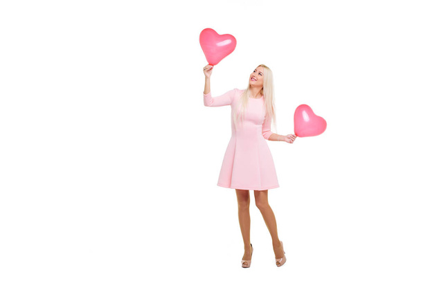 Beautiful young blond woman with heart shape pink air balloon on white isolated background. Woman on Valentine's Day. Symbol of love - Image - Foto, afbeelding