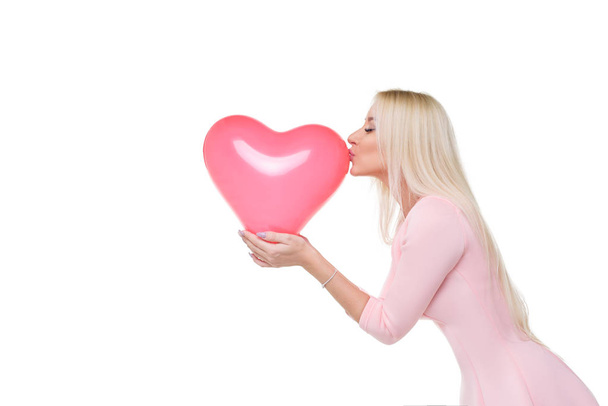 Beautiful young blond woman with heart shape pink air balloon on white isolated background. Woman on Valentine's Day. Symbol of love - Image - Foto, immagini