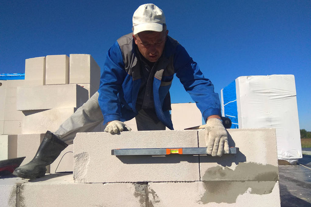 Il lavoratore controlla il muro dei blocchi di gas da un livellatore 2018
 - Foto, immagini