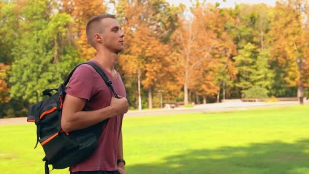 estudante vestindo roupas casuais caminha no parque da cidade
 - Filmagem, Vídeo