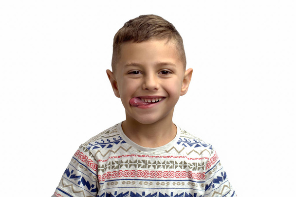portrait d'un garçon joyeux sur fond blanc qui fait une grimace et montre la langue
 - Photo, image
