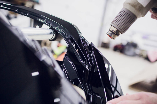 Worker hands installs car paint protection film wrap bumper - Foto, immagini