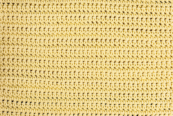 Fragmento de tejido de punto amarillo real hecho de fibras de lana con textura de fondo, con un patrón delicado
. - Foto, imagen