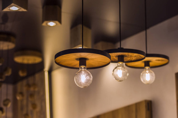 Led light lamp illuminated. Installation of a geometric hanging wooden chandelier. - Zdjęcie, obraz