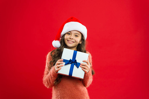 Happy winter holidays. Small girl. New year party. Santa claus kid. Little girl child in santa red hat. Present for Xmas. Childhood. Christmas shopping. present box - Фото, зображення