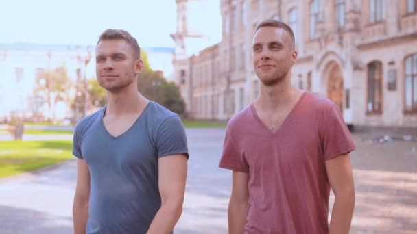 Kaukasische jonge mannen lopen op het gebied van de campus - Video