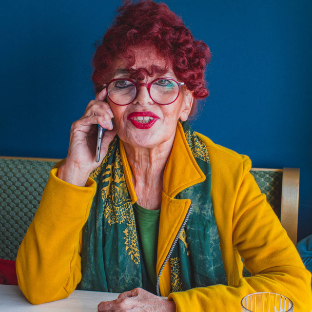 ελκυστική γυναίκα ανώτερος συνταξιούχος, θηλυκό μιλώντας έξυπνο τηλέφωνο σε καφετέρια, την ηλικία και τη ζωή την έννοια - Φωτογραφία, εικόνα