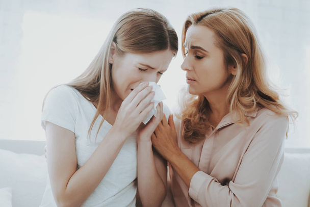 Woman Comforts Unhappy Teenage Daughter at Home. Sitting at Home on Couch. Girl with Problem. Conflict in Family. Parent and Child. Unhappy Girl. Communication Concept. Relationship Concept. - Photo, image