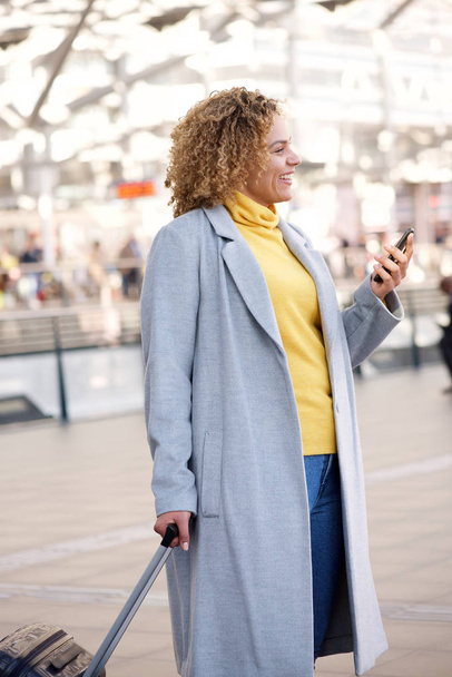 Straně portrét usmívající se žena afroamerické cestování na stanici s mobil - Fotografie, Obrázek