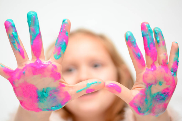 Šťastné dítě hraje s barvou, kterou dívka má na rukou a prstů - Fotografie, Obrázek