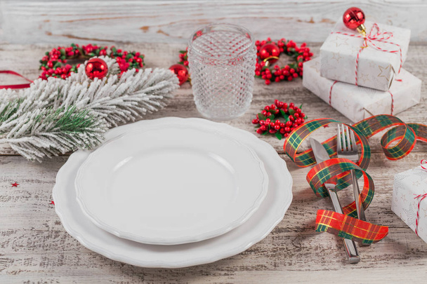 Winter place setting with Christmas and New Year decorations on white wooden table. Festive table setting for Christmas dinner. - Φωτογραφία, εικόνα