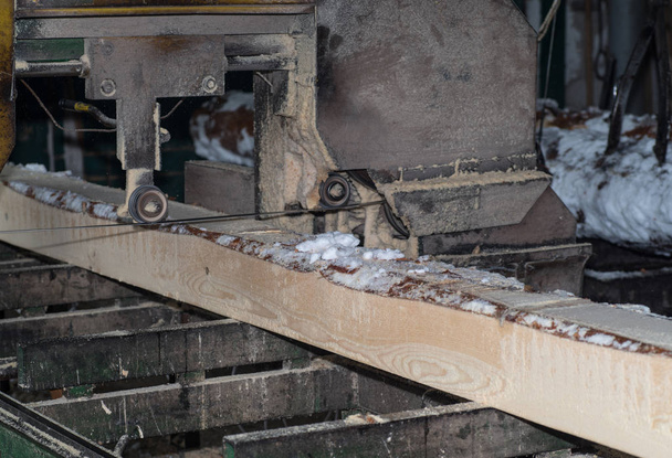 Couper des bûches sur les planches. Dans le processus d'hiver un arbre.Traitement du bois
. - Photo, image