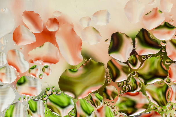 Μακρο φωτογραφία. Αφηρημένο aqua μοτίβο ως φόντο. Στριμμένα αντανακλάσεις σε σταγονίδια νερού. Πράσινες και κόκκινες κηλίδες και τις γραμμές, επίσης το πολυώροφο κτίριο. - Φωτογραφία, εικόνα