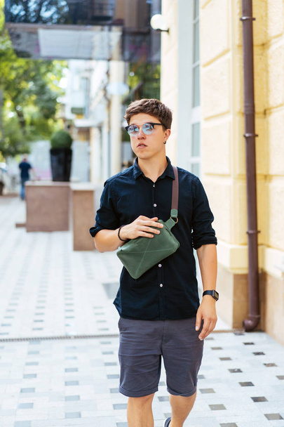 Young guy in round sunglasses posing on camera. - Fotó, kép