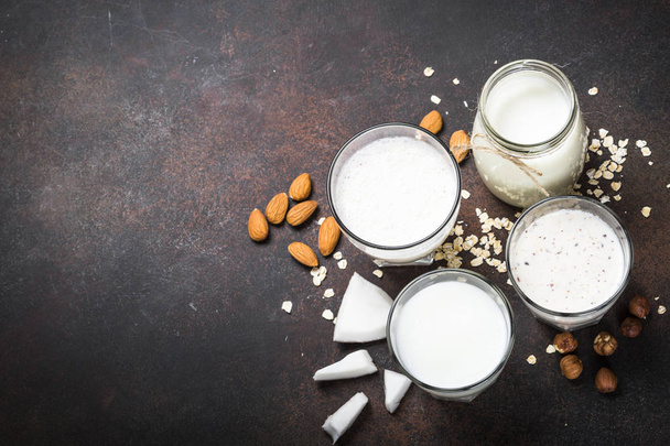 Веганський немолочний альтернативний вид зверху на молоко, горіхи та вівсяне молоко
.  - Фото, зображення