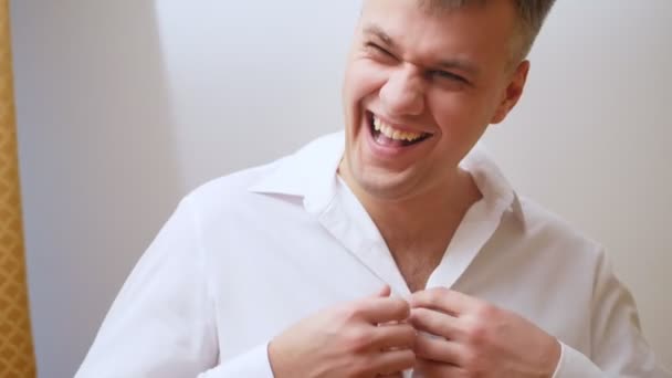 portrait of Handsome, cheerful, laughing man of thirty years old is dressing white shirt - Video