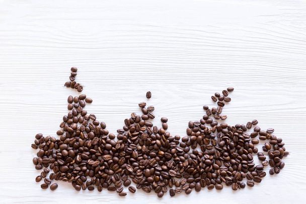 múltiples granos de café tostados sobre fondo de madera estructural blanca, planas
 - Foto, imagen