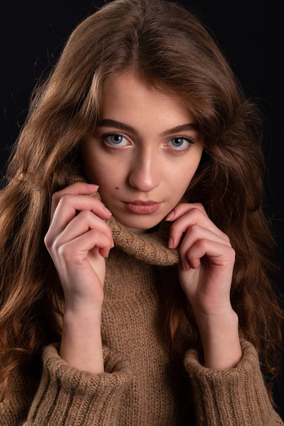 Close up retrato de uma jovem em uma camisola no fundo escuro
 - Foto, Imagem