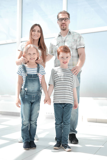 brother and sister with their parents standing in a spacious apartment - Foto, Bild