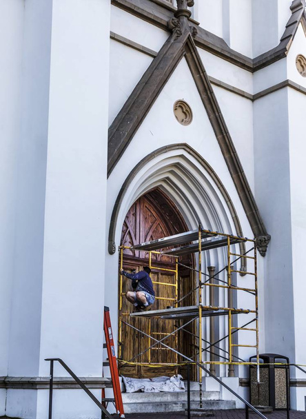 Hombre mancha puerta de la iglesia
 - Foto, Imagen