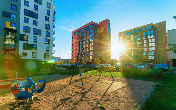 Apartment house building complex concept. Street with children playground. With sun light - 写真・画像