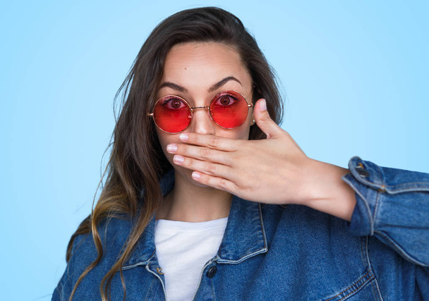 Expressive teenage girl covering mouth  - Fotó, kép