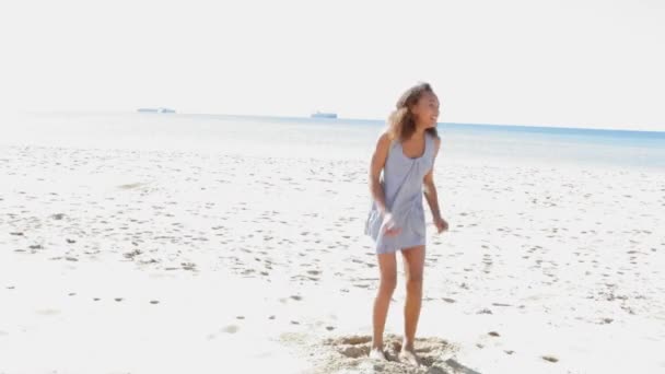 Девушка прыгает на пляже с белым песком
. - Кадры, видео