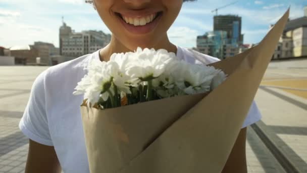 Extremely happy afro-american girl sniffing beautiful bouquet aroma and smiling - Záběry, video