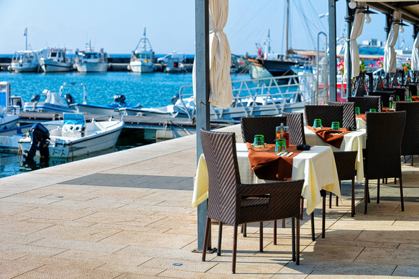 Café de rua na calçada no Mar Adriático e Marina em Izola, Eslovênia
 - Foto, Imagem