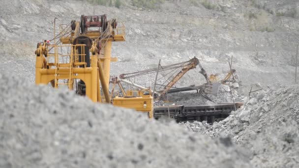 Escavatore che sposta minerale in vagone ferroviario nella cava. Attrezzature pesanti
. - Filmati, video