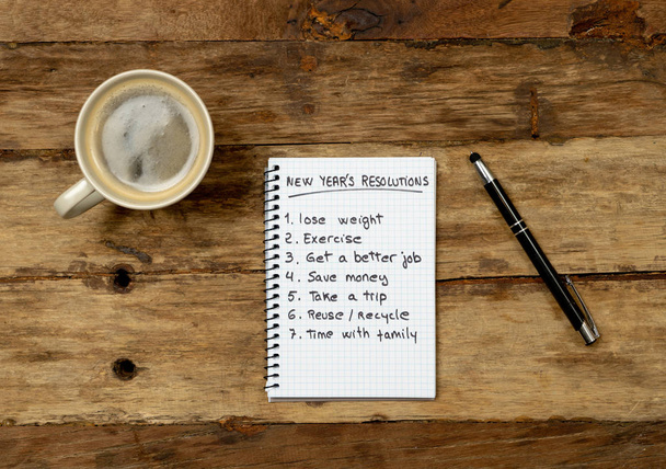 Top View 2019 New year resolutions list with wishes for new lifestyle written on notepad coffee and pen on Vintage wooden table in Wish list and Goals for happiness Aspiration and Motivation Concept. - Foto, immagini
