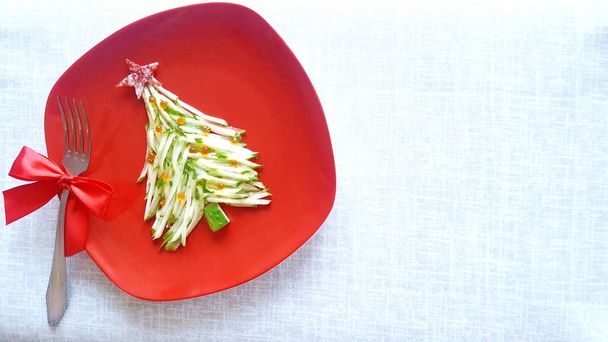 Christmas tree is made of sliced cucumber and decorated with red caviar. New years design of dishes. New years food. Food for the new year holiday. Decoration of dishes. - Photo, Image