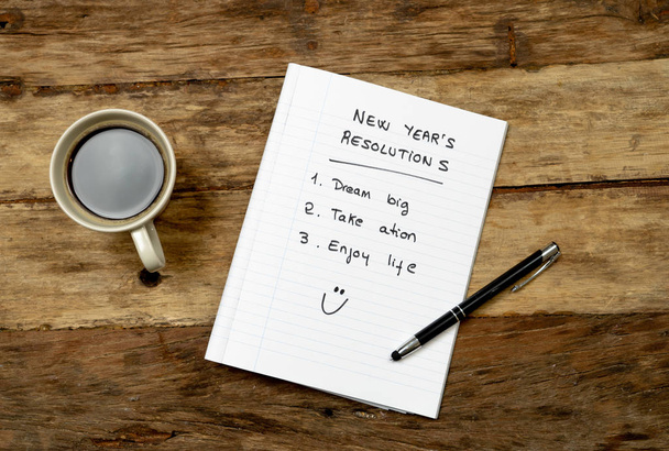 Top View 2019 Lista de resoluções de ano novo com planos para uma nova vida rosto feliz escrito no café notepad e caneta na mesa vintage em sonhos e metas para a felicidade Conceito de aspiração e motivação
. - Foto, Imagem