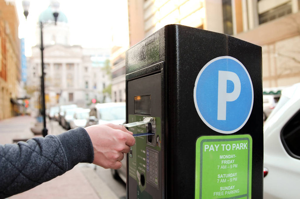 Mann bezahlt seinen Parkplatz am Parkautomaten mit Kreditkarte - Foto, Bild
