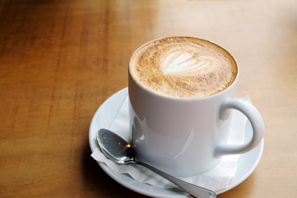 Hot latte on a wooden table - Valokuva, kuva