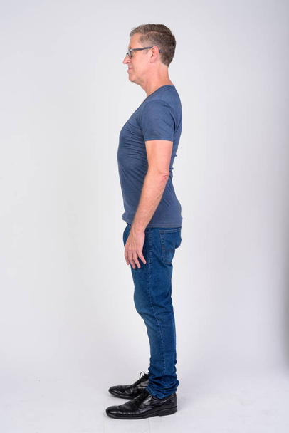 Full body shot profile view of mature man against white background - Photo, Image