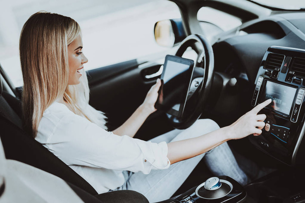 Woman In Tesla Car. Behind The Wheel Concept. Innovation Technology. New Generation Electro Hybrid Vehicle. Luxury Design. Futuristic Power. Hand On Display. Inside View. Front Seat. - Photo, image