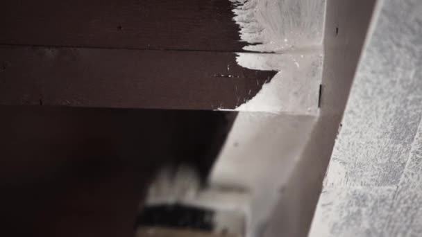 Hand eines männlichen Arbeiters bemalt professionell graue Wand in weißer Farbe mit großem Pinsel - Filmmaterial, Video