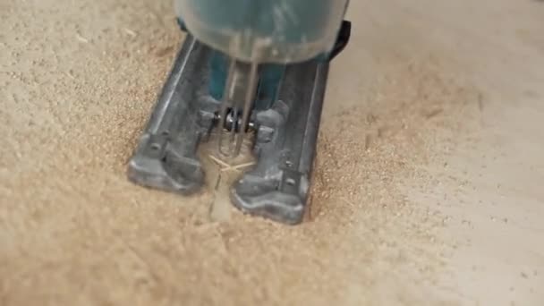 Closeup process of green dusty electric jigsaw cutting wooden plank. - Footage, Video
